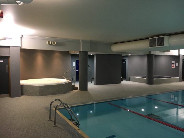 An example of a resin sand system swimming pool surround and wall covering installed at an indoor leisure centre